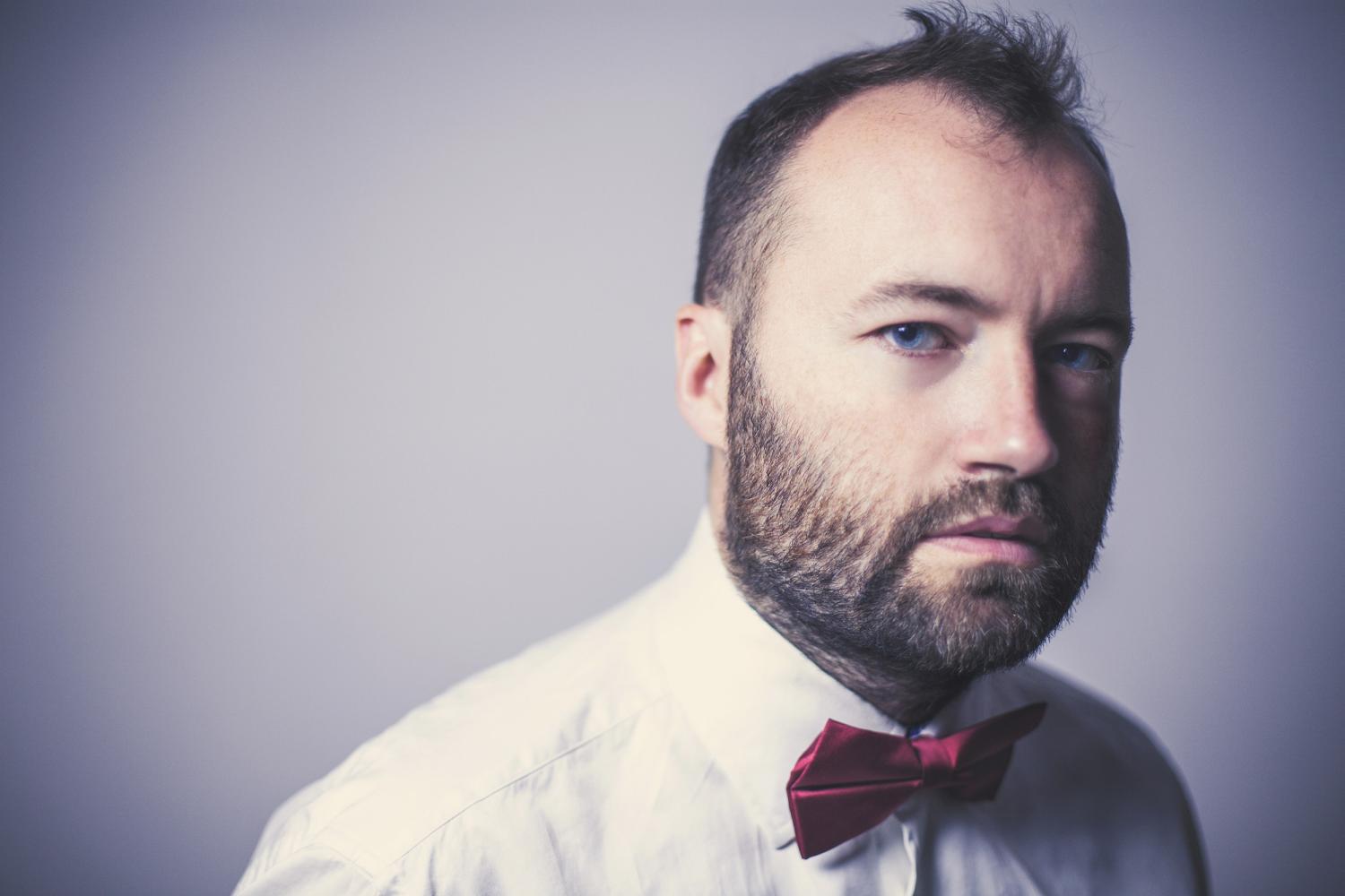 Pianista w białej koszyli i czerwoną muszką